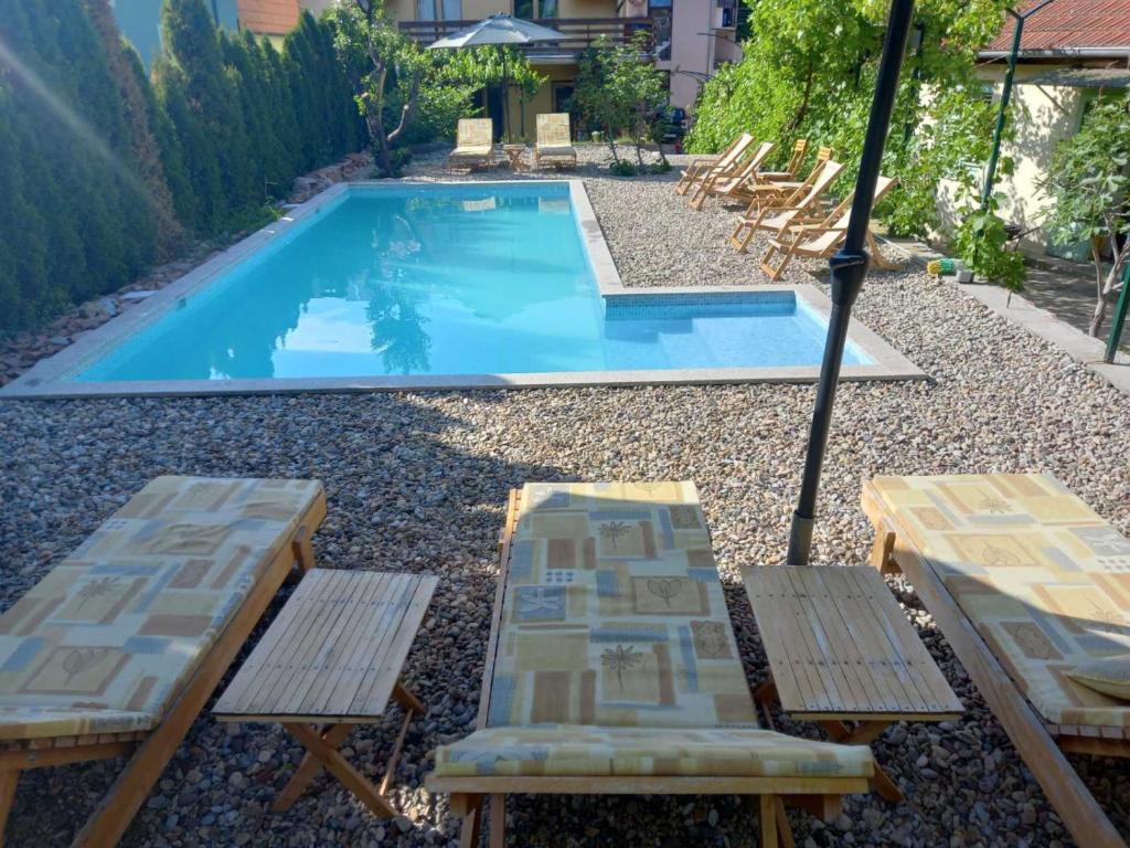 a swimming pool with two lounge chairs and an umbrella at Apartmani ,,Vasa ,, 3 in Soko Banja