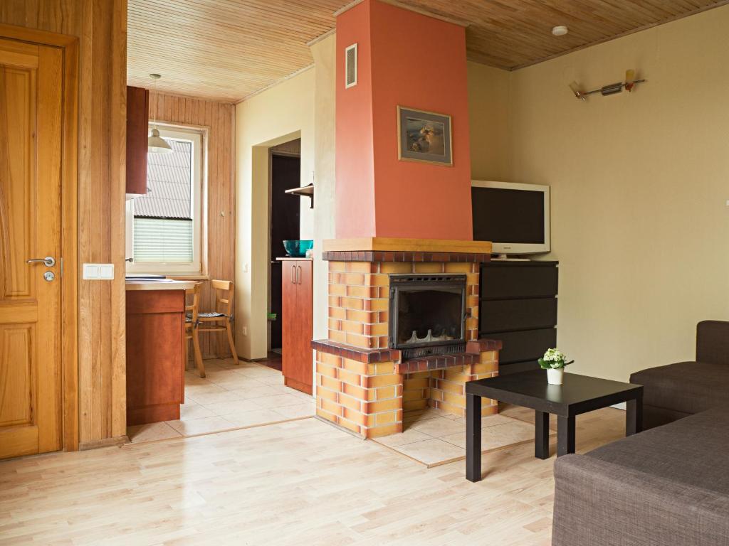 a living room with a fireplace and a tv at Old Palanga Apartments in Palanga
