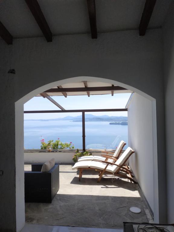um quarto com uma varanda com vista para o oceano em Aris Studio Corfu em Pyrgi