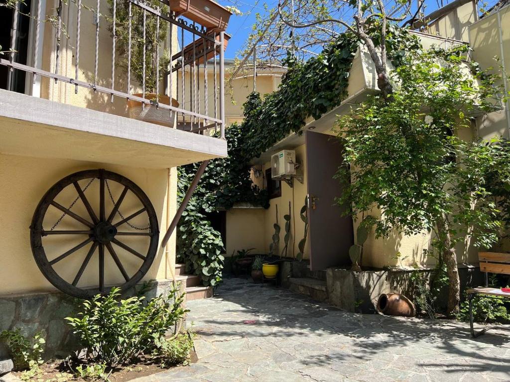 un bâtiment avec une roue de wagon sur son côté dans l'établissement Georgian House, à Tbilissi