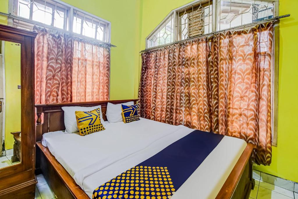 sypialnia z łóżkiem i oknem z zasłonami w obiekcie OYO Homes 91124 Desa Wisata Kaso 