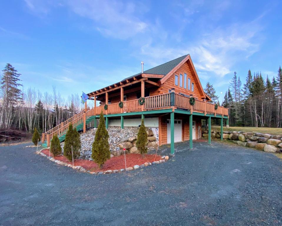 uma casa de madeira com um deque e um quintal em Cozy modern log cabin in the White Mountains - AC - granite - less than 10 minutes from Bretton Woods em Carroll