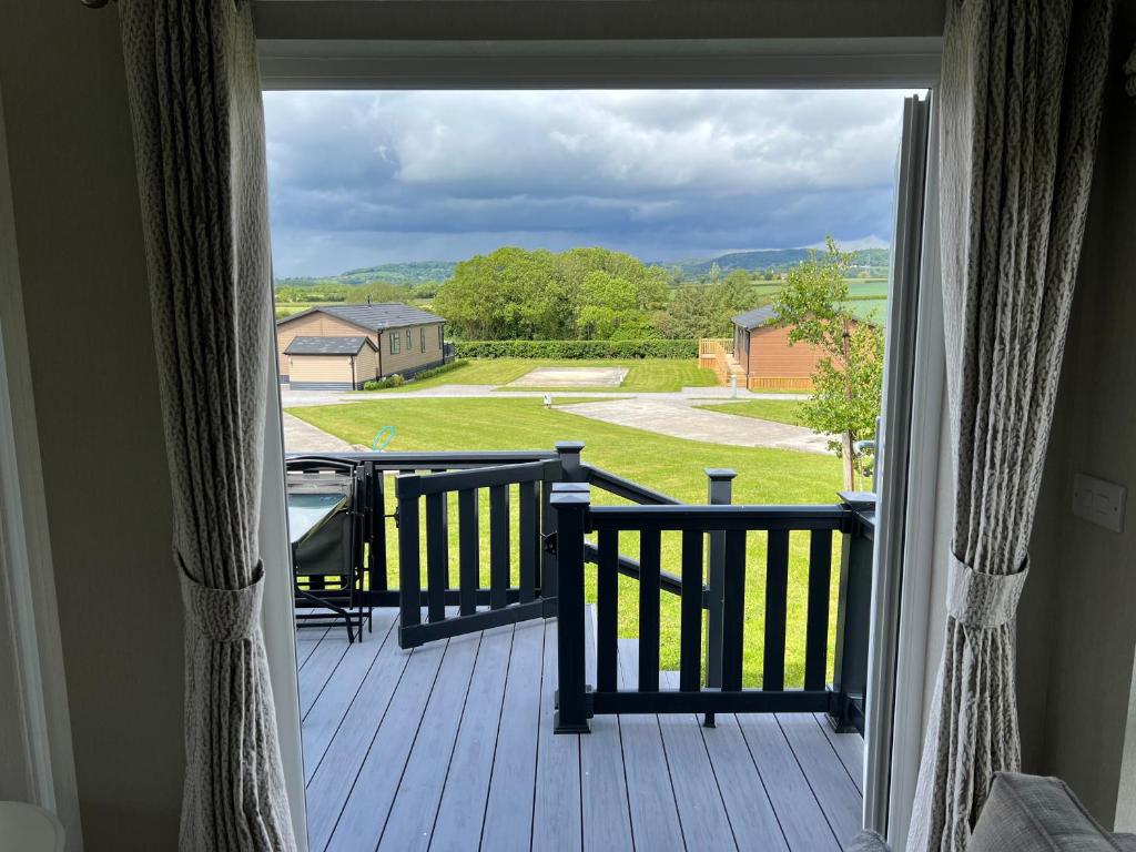 a door to a porch with a view of a yard at Meadow View Lodge with stunning views in Thirsk