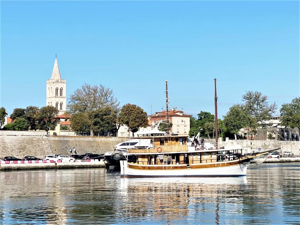 a boat is docked in the water near a harbor at Rhythm Floating Hostel - Zadar in Zadar