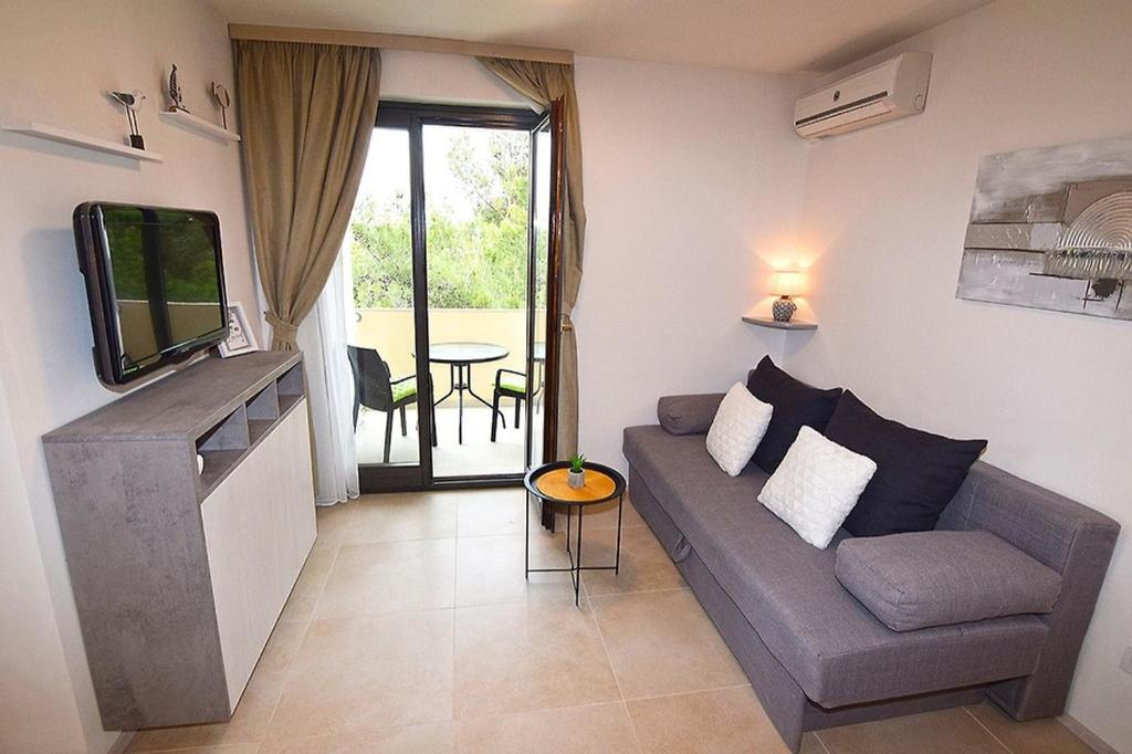 a living room with a couch and a television at Sole Pula Apartman-near beach in Pula