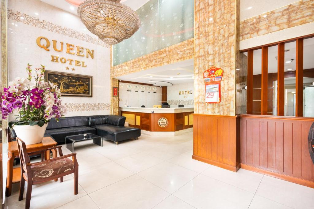 ホーチミン・シティにあるQueen Hotel Airportの花とソファのあるホテルのロビー
