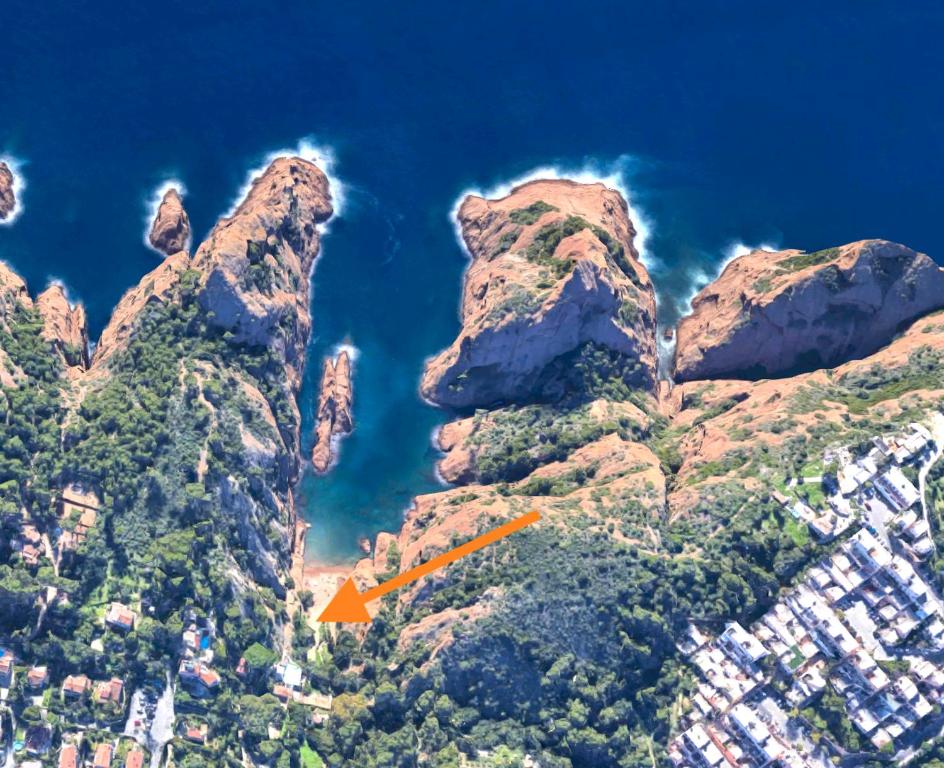 an orange house on the side of a mountain at La Calanque de Figuerolles in La Ciotat