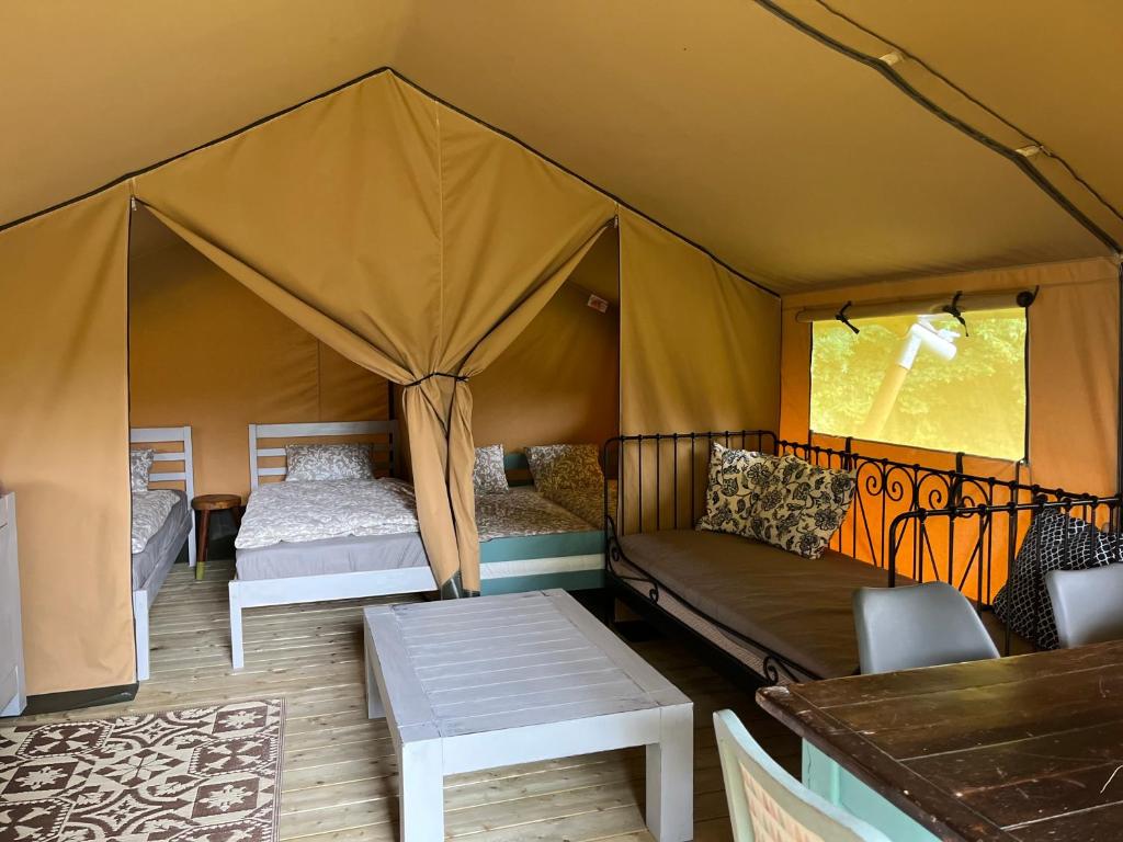 ein Zelt mit 2 Betten und einer Couch darin in der Unterkunft Rendes Glamping in Balatonrendes
