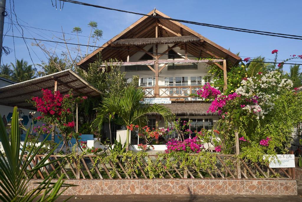 une maison avec des fleurs devant elle dans l'établissement Serenity Luxurious Beachfront Villa & Spa with private Infinity Pool, 8 Guests, à Gili Air