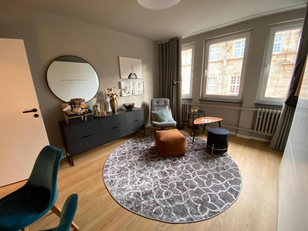a living room with a mirror and a chair at Modernes Apartment no5 in bester Stadtlage in Kassel