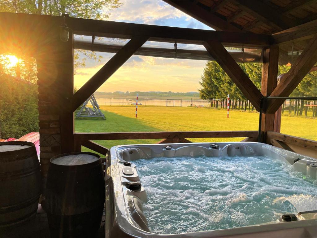 a hot tub in a gazebo with a view of a field at Siedlisko Miluki in Ełk