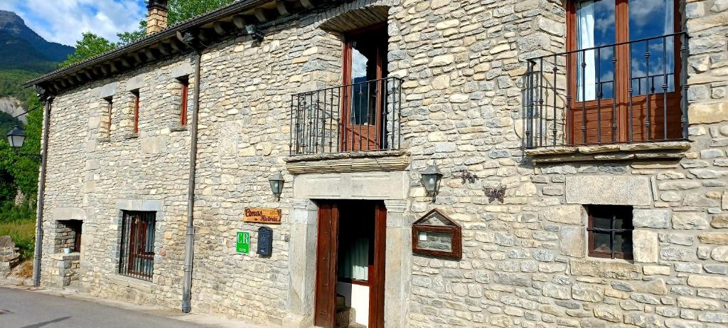 un antiguo edificio de piedra con ventanas y una puerta en Cimas con historia, en Fiscal