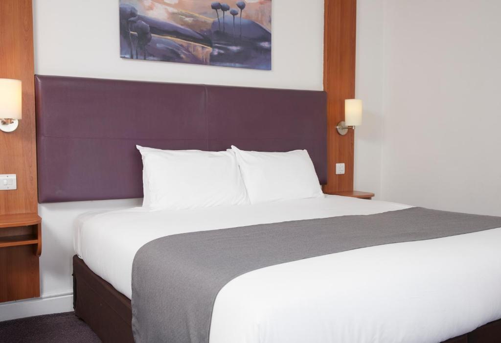 a bedroom with a large white bed with a purple headboard at Wheatsheaf by Chef & Brewer Collection in North Waltham