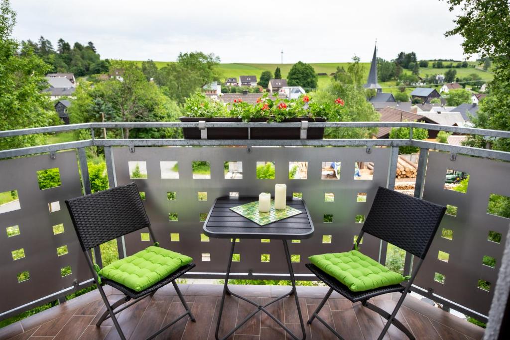 a patio with a table and chairs on a balcony at Steinbachblick in Steinbach am Wald