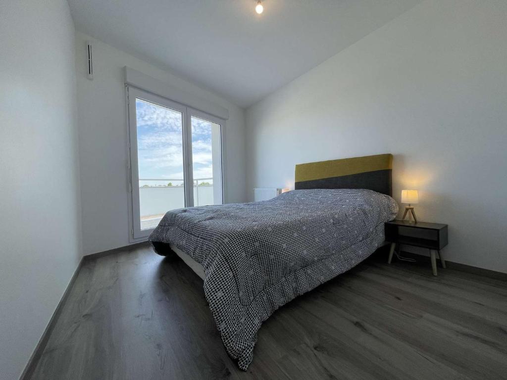 a bedroom with a bed and a large window at Appartement La Rochelle, 3 pièces, 4 personnes - FR-1-246-588 in La Rochelle
