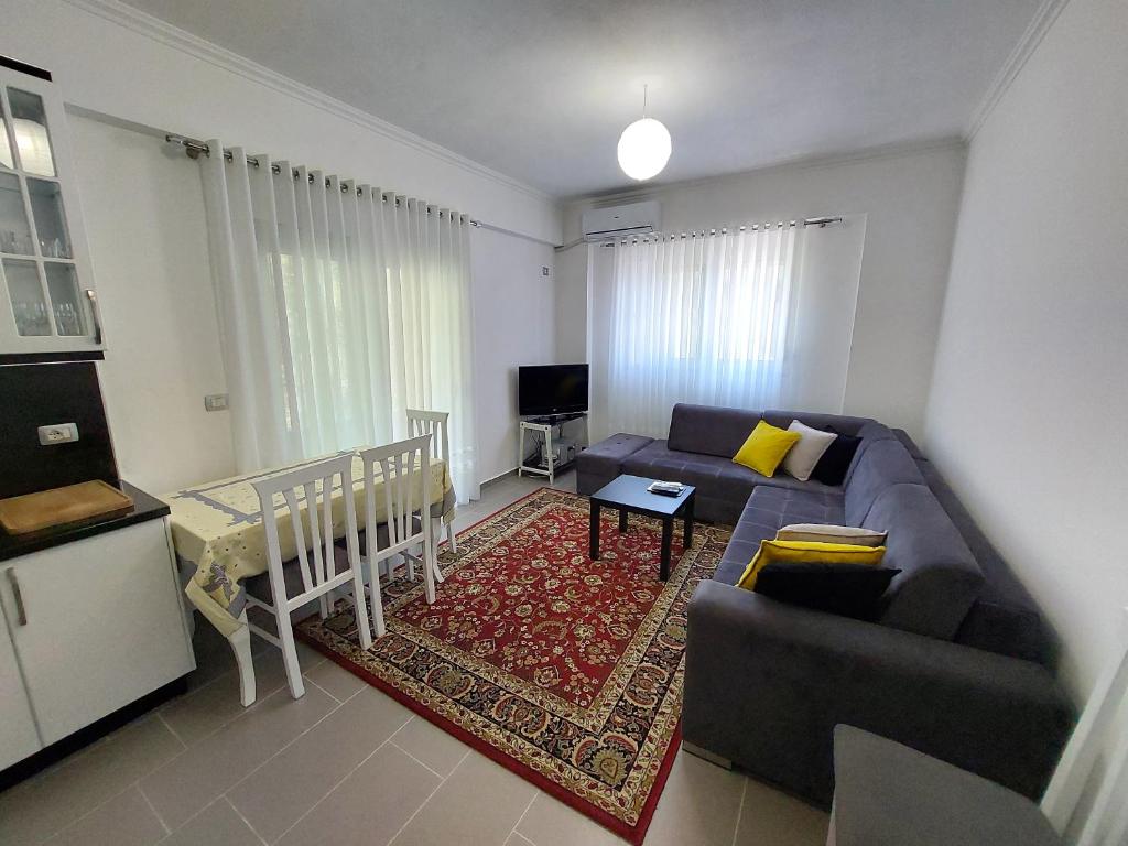 ein Wohnzimmer mit einem Sofa und einem Tisch in der Unterkunft Tina's 1-bedroom condo apartment in Gjirokastër