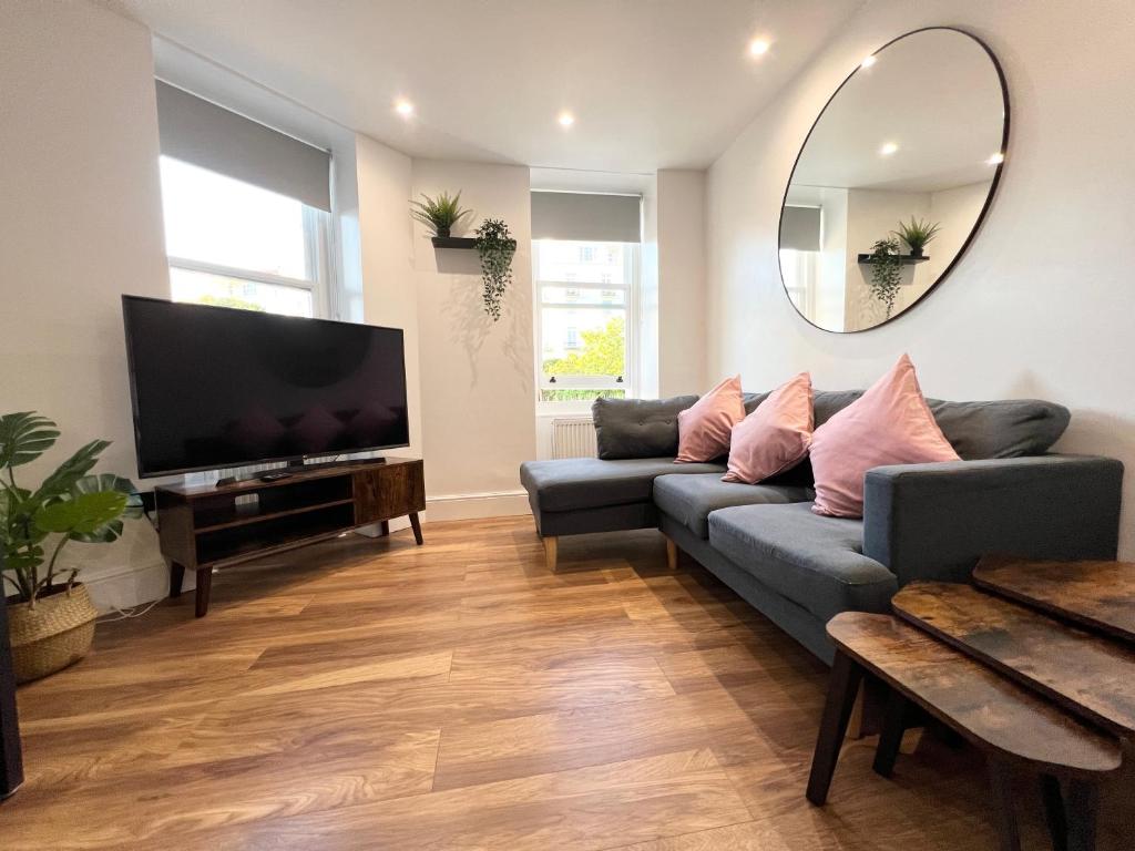 a living room with a couch and a flat screen tv at Lovely Apartment, One Minute from Bournemouth Beach and Town. in Bournemouth