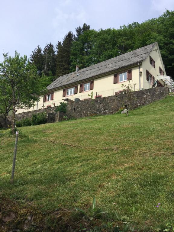 een huis op een heuvel met een stenen muur bij gîte la Fonderie in Fréland