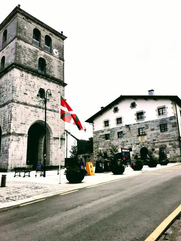 a building with a flag on the side of a street at Arangiz Etxea in Aulestia