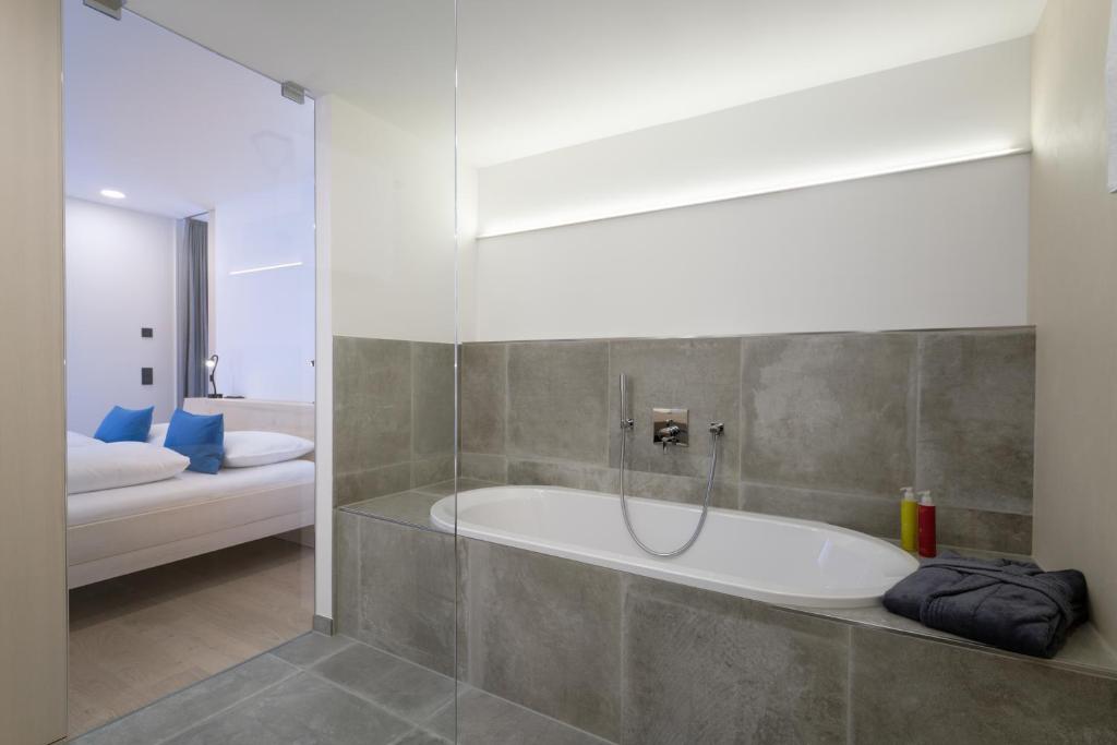 een badkamer met een bad en een douche bij Alpin Chalet Trinkl in Bad Wiessee