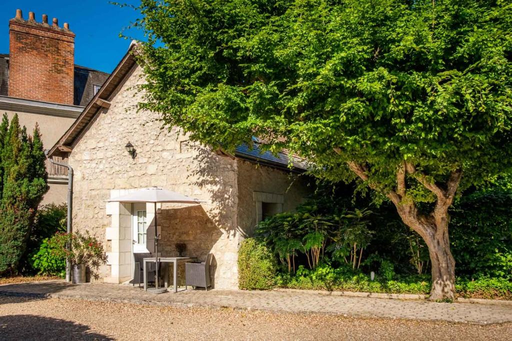 a house with a tree next to a building at Le Pavillon des Lys - Hôtel Particulier in Amboise