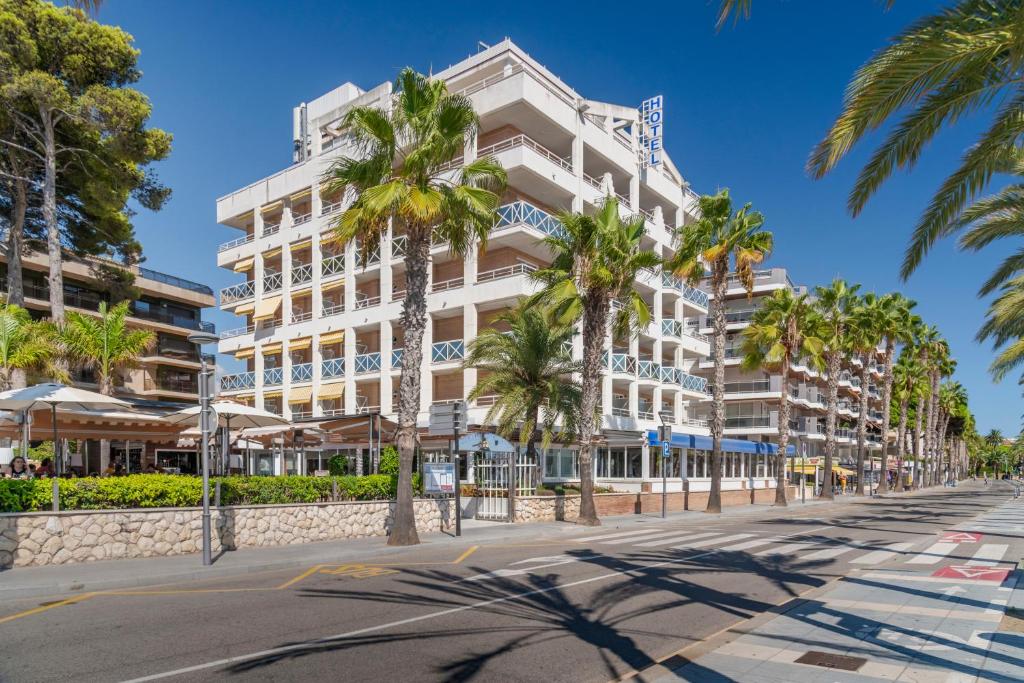 een groot wit gebouw op een straat met palmbomen bij 4R Casablanca Playa in Salou