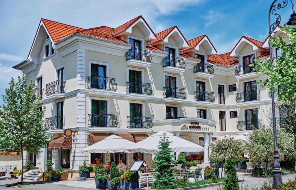 un grand bâtiment blanc avec des toits rouges dans l'établissement Radsor Hotel, à Râșnov