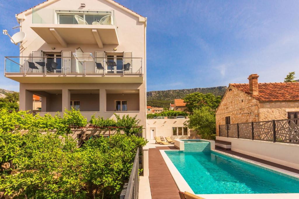 a villa with a swimming pool and a house at Bol Summer Residence in Bol