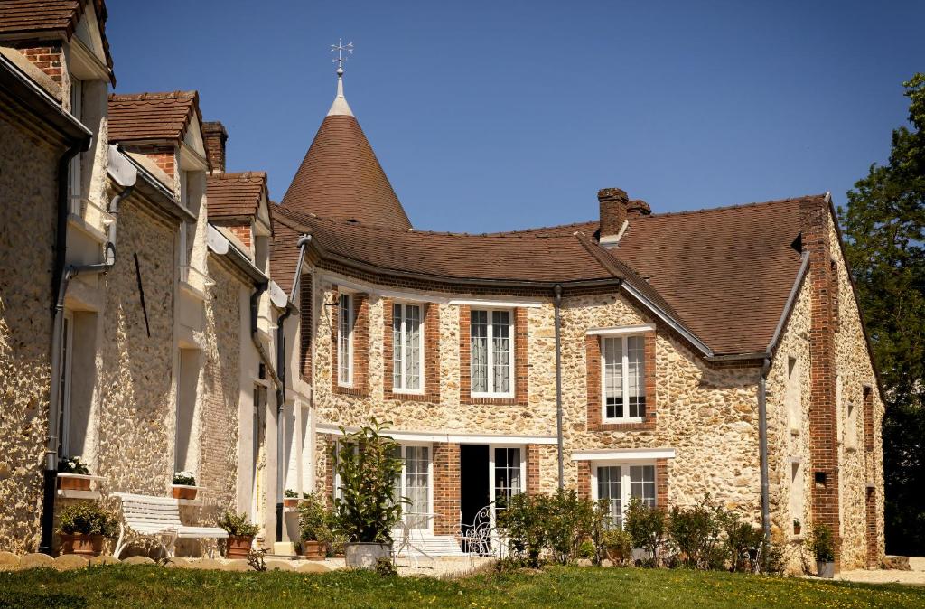 uma grande casa de tijolos com telhado em Le Petit Château em Baye