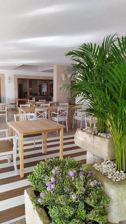 a restaurant with a wooden table and chairs and flowers at Hotel Nou Can Guillem in Cala Figuera