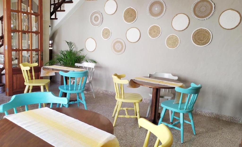 a restaurant with tables and chairs and mirrors on the wall at Hotel Nou Can Guillem in Cala Figuera