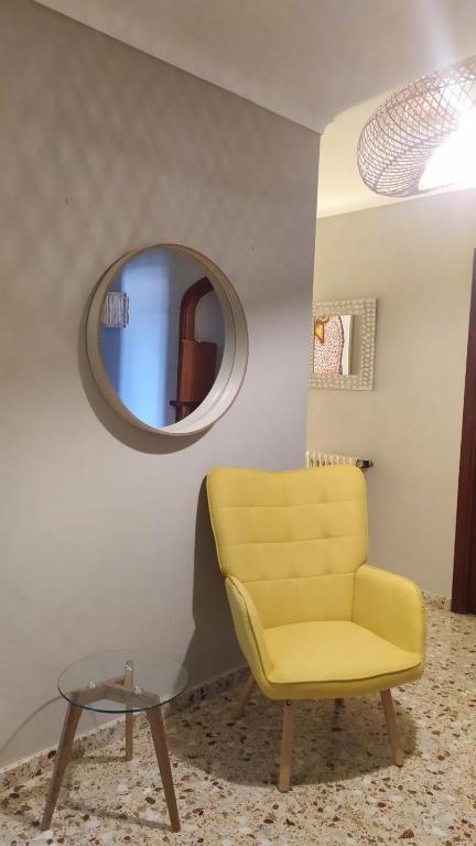 a yellow chair in a room with a mirror at Hotel Nou Can Guillem in Cala Figuera
