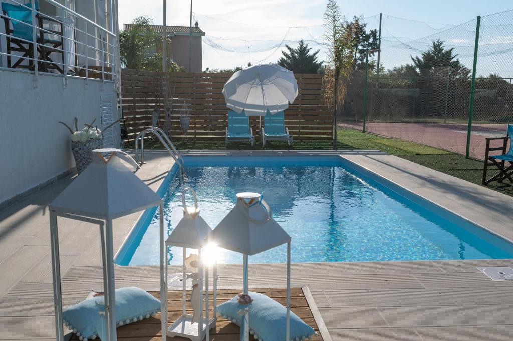 a swimming pool with two umbrellas sitting next to it at Le petit luxury apartment in Preveza