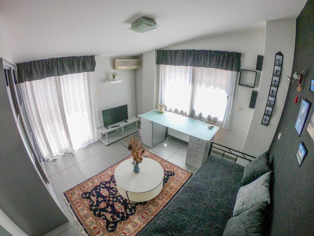 einen Blick über ein Wohnzimmer mit einem Tisch in der Unterkunft Piraeus Urban Paradise L in Piräus