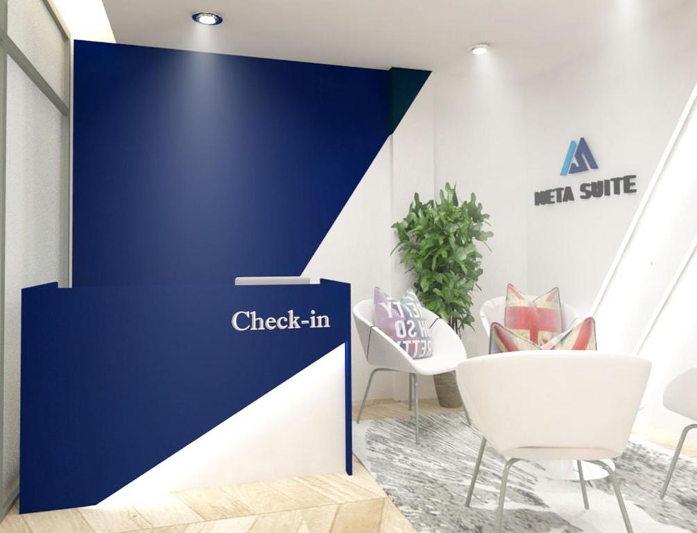 a blue wall with a sign that reads check in at Meta Hotel in Kuala Lumpur