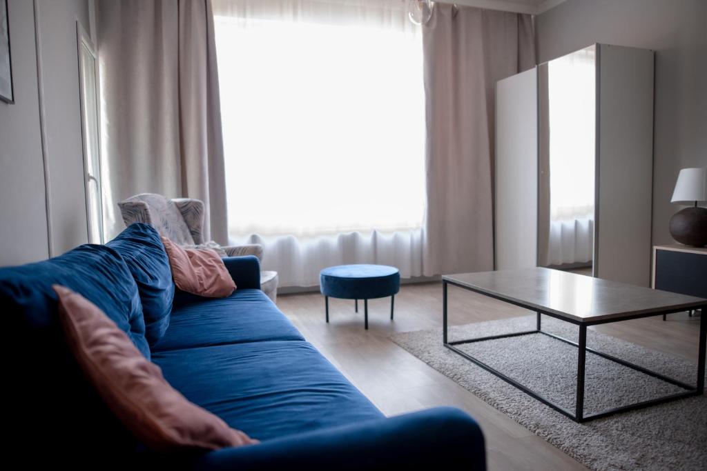 a living room with a blue couch and a table at Chopin's Apartment in Bielsko-Biała