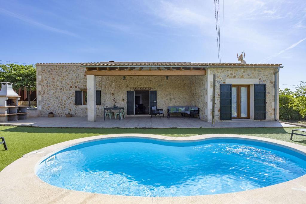 a villa with a swimming pool in front of a house at Finca Coqueta in El Port de la Selva