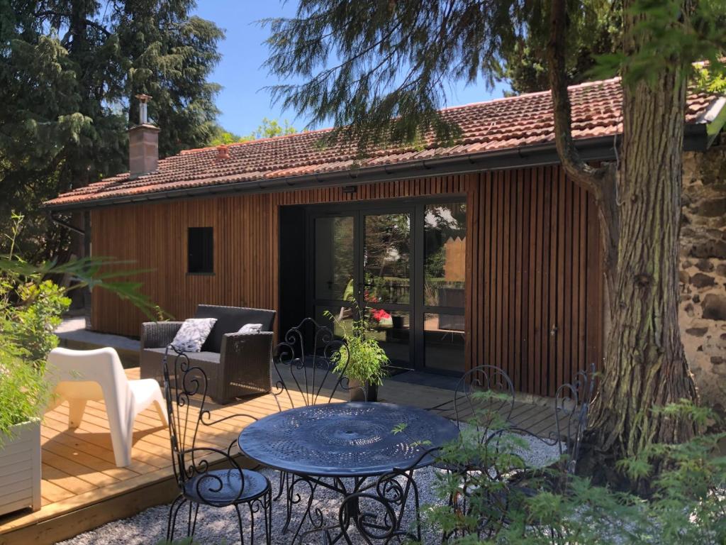 un patio con mesa y sillas en una terraza en La grange de l ocean SPA, en Linxe