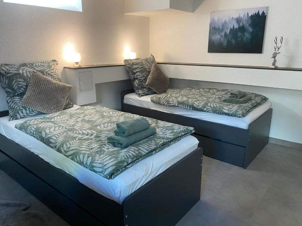 two beds sitting next to each other in a room at city-house-bühl in Bühl