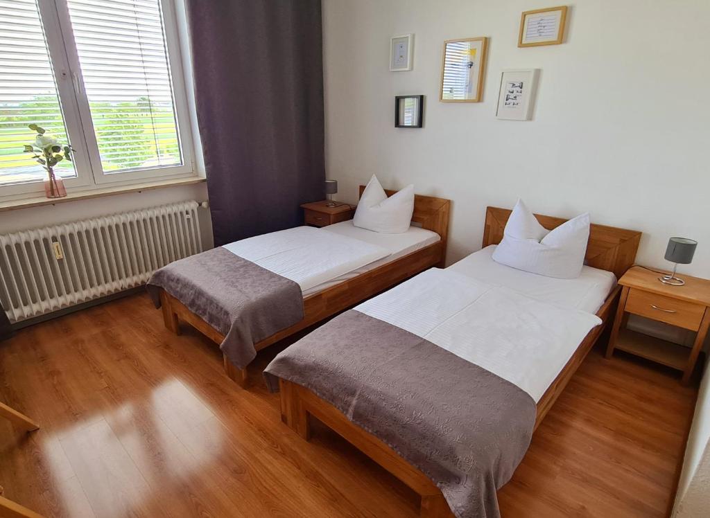 een kamer met 2 bedden en een raam bij Horn Gästehaus in Leinfelden-Echterdingen