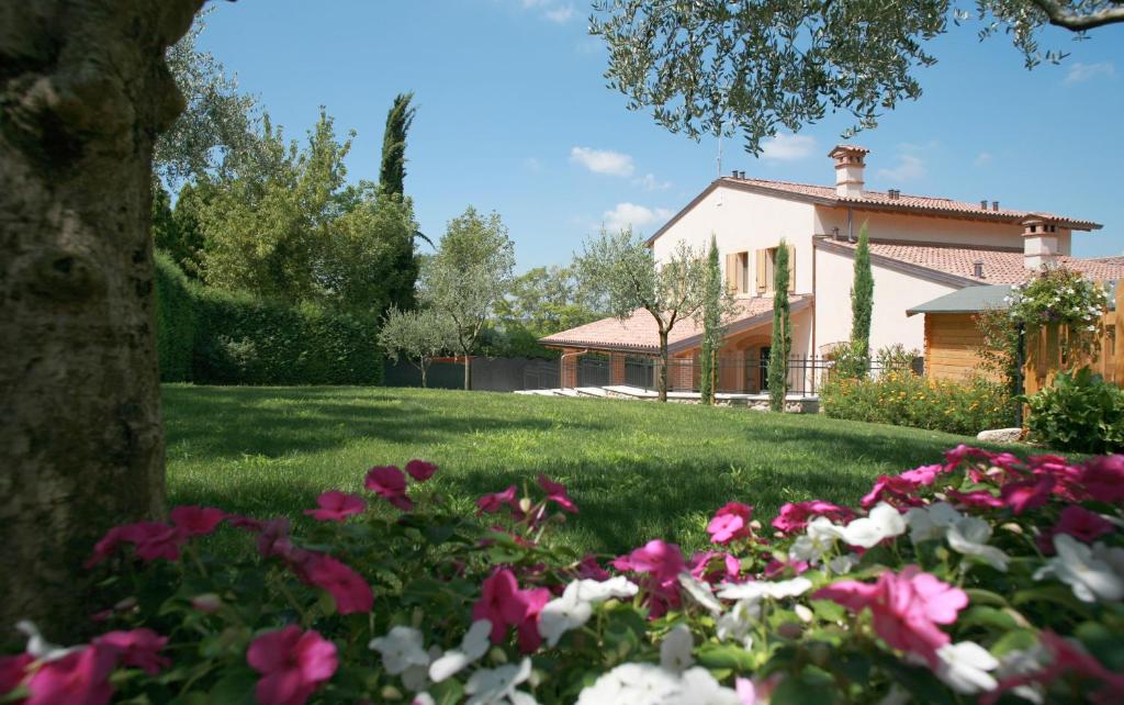 ein Haus mit rosa Blumen im Hof in der Unterkunft Cortecoraman in Sommacampagna