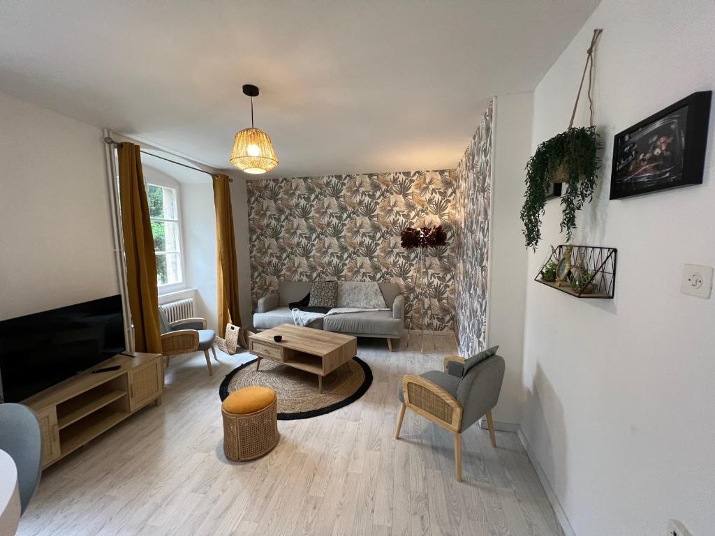 a living room with a couch and a tv at Ca s'est passé à la Cour-Aux-Moines in Porrentruy