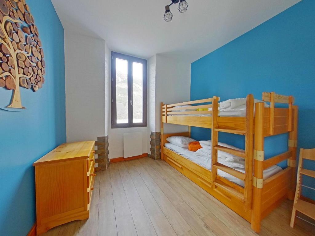 a room with two bunk beds and a desk at Appartement entier T4 à Jausiers in Jausiers