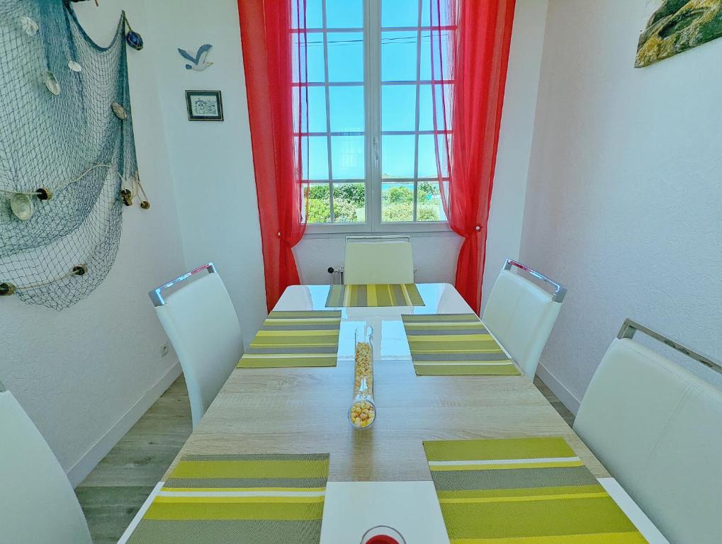 a room with a long table with chairs and a window at La Villa Ty Reun - Vue mer et Plage à 100m in Plouguerneau