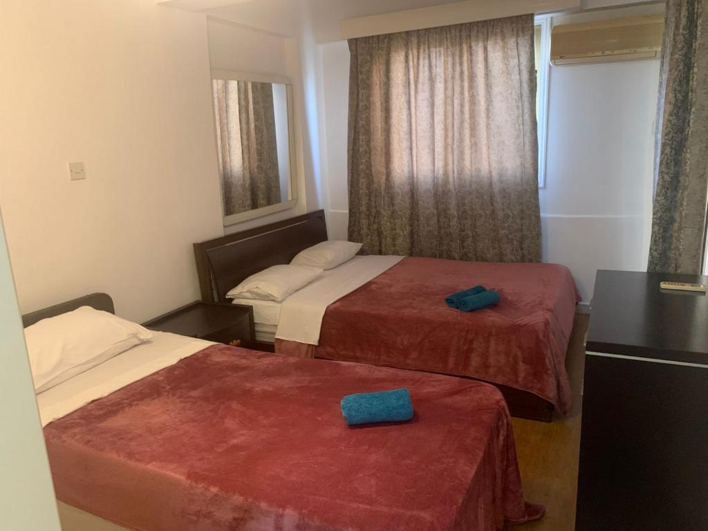 a hotel room with two beds and a mirror at Green Nondas Hill A in Larnaca