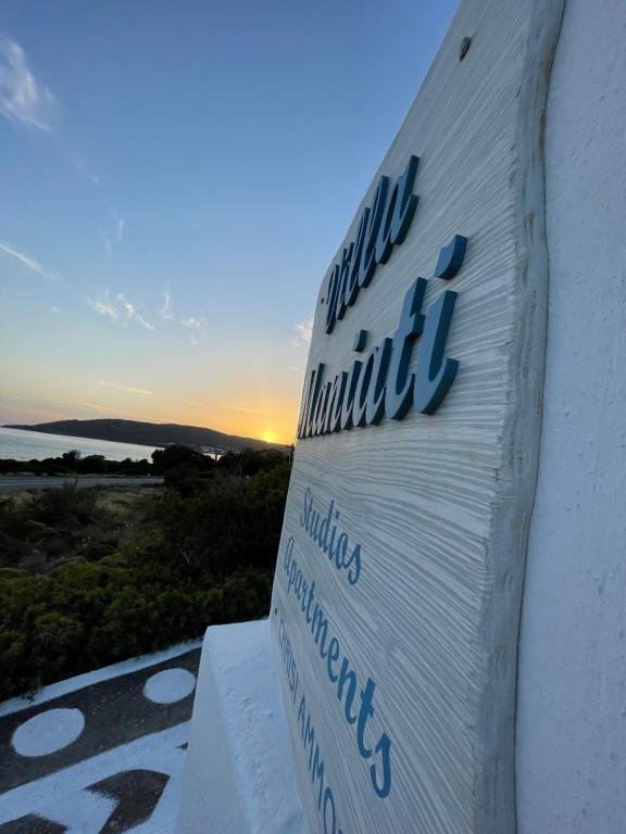a sign for a hotel with the sunset in the background at Villa Maniati Studios in ayios Petros
