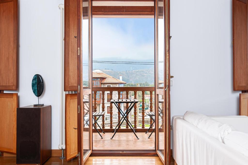 een woonkamer met een deur naar een balkon bij Vivienda Vacacional Leo in Andrín