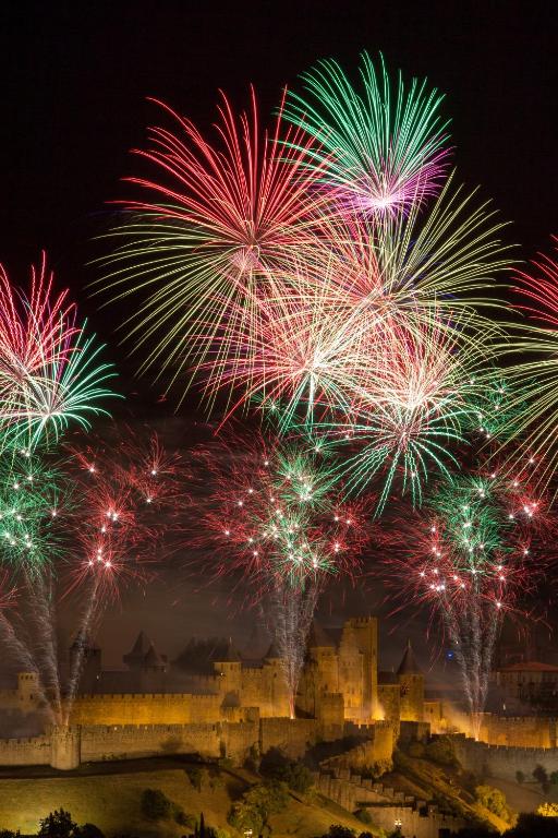 un feu d'artifice au-dessus d'une ville avec un château dans l'établissement L'Atelier B&B, Amazing View & SPA, à Carcassonne