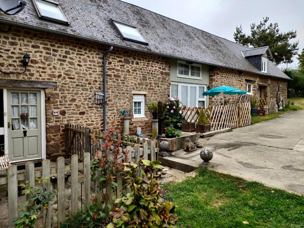 a brick house with a fence in front of it at Les Petits Champs in Buais