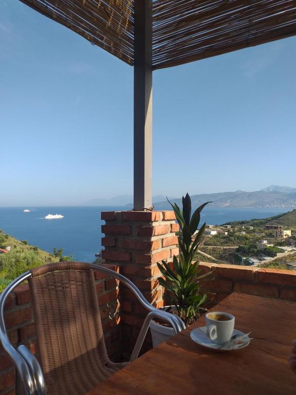 a table with a cup of coffee on top of a house at Grand Seaview Apartments in Ksamil